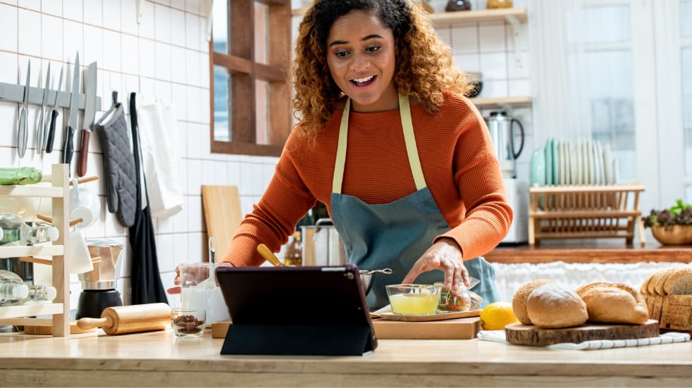 Woman preparing a meal from an online tutorial